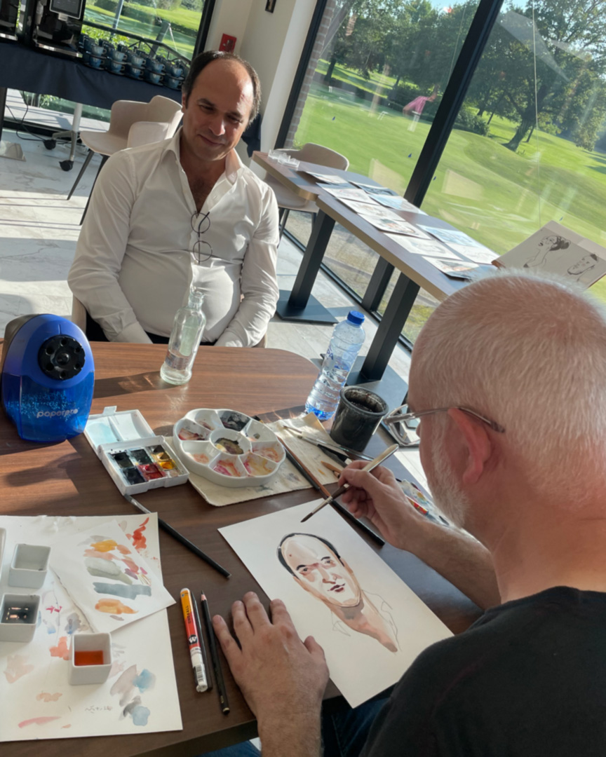 Serge Dehaes en train de faire le portrait d'un golfeur