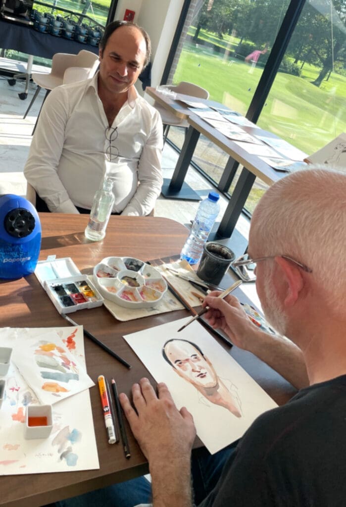 Serge Dehaes en train de faire le portrait d'un golfeur